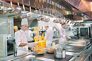 Modern kitchen. Cooks prepare meals on the stove in the kitchen of the restaurant or hotel. The fire in the kitchen.