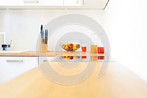 Modern kitchen counter with induction hob, fresh fruit and homemade lemonade