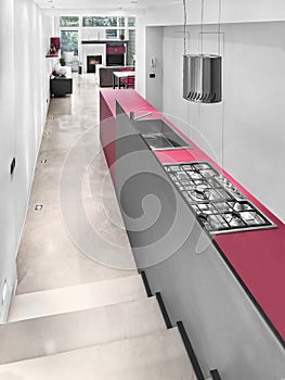 View of a modern kitchen overlooking the living room with fireplace