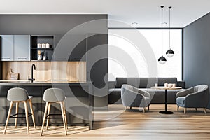 Modern kitchen interior with gray walls, a wooden floor and huge panoramic window. A bar table and small dining table with