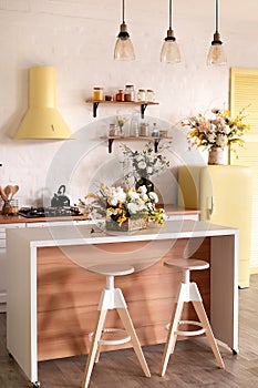 Modern Kitchen Interior with Island, Sink, Cabinets, and Big Window in New Luxury Home Decorated With Flowers