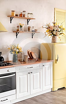 Modern Kitchen Interior with Island, Sink, Cabinets, and Big Window in New Luxury Home Decorated With Flowers