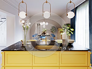 Modern kitchen island in yellow kitchen with pendant lamp over, yellow furniture black countertop