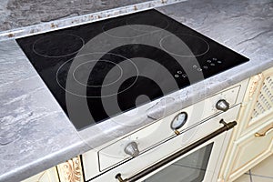 Modern kitchen luxurious interior with black induction or electric hob stove cooker with ceramic top surface with marble