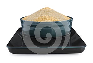 Modern kitchen scale with bowl of brown sugar isolated on white