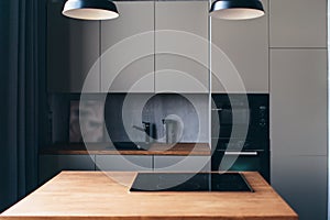 Modern kitchen with table and built-in hob. Interior design