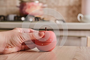 Modern kitchen timer apple shaped on the background of the kitchen