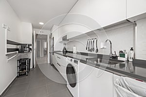 Modern kitchen with white cabinets combined with black stone countertop