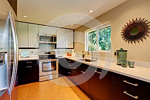 Modern kitchen with white countertops, white and brown new cabinets.