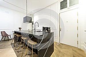 Modern kitchen with wood and black marble center island, matching