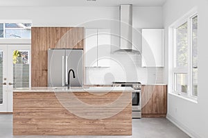 A modern kitchen with wood and white cabinets.