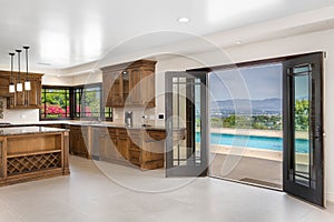 Modern kitchen with wooden cabinets and white tile flooring in Encino, California