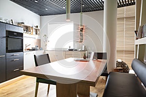 modern kitchen with wooden dining table and bench with window