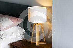 Modern Lamp on Bedside Table and a Cozy Set of Pillows on the Bed