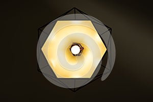 Modern lamp hanging down from ceiling in the dark background