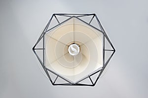 Modern lamp hanging down from ceiling on white wall background