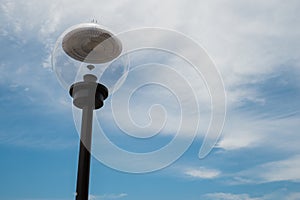 Modern lamp post against a blue cloudy sky