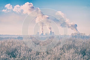 Modern landscape with factory pipes at distance from which smoke is polluting the air