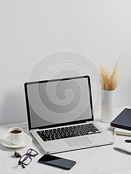 Modern lap top template mock up on white and clean work desk with blank screen Workspace desk, laptop, coffee cup and pen. laptop