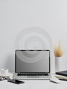 Modern lap top template mock up on white and clean work desk with blank screen Workspace desk, laptop, coffee cup and pen. laptop