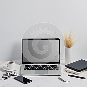 Modern lap top template mock up on white and clean work desk with blank screen Workspace desk, laptop, coffee cup and pen. laptop