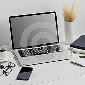 Modern lap top template mock up on white and clean work desk with blank screen Workspace desk, laptop, coffee cup and pen. laptop