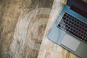 Modern laptop computer on rustic wooden background, top view