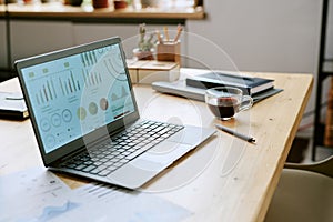 Modern Laptop Displaying Business Analytics Dashboard on Wooden Office Desk