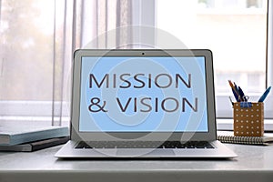 Modern laptop with phrase MISSION AND VISION on screen