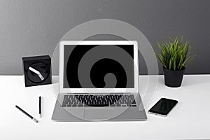 Modern laptop on table against gray wall