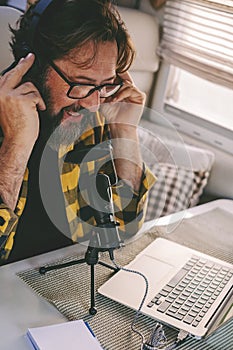 Modern laptop work concept. Young adult man telling and recording on microphone with computer internet connection to creat web