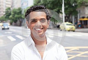 Modern latin guy with toothy smile in the city