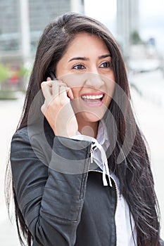 Modern latin woman with phone in the city