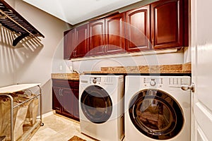 Modern laundry room with cabinets and granite top