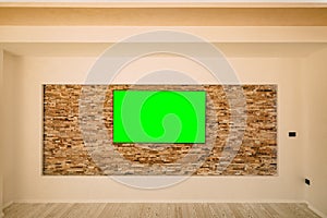 A modern LCD TV with a green screen hanging