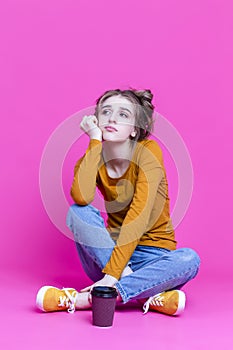 Modern Lifestyle. One Beautiful Sad Depressed Caucasian Girl With Paper Disposable Cup Posing Sitted WIth Drink Against Seamless