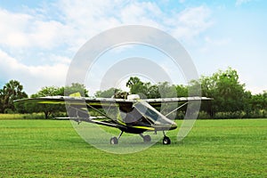 Modern light aircraft on green grass outdoors