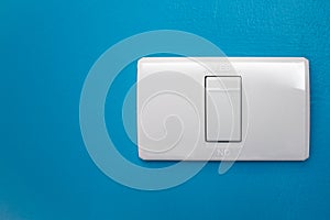 Modern light switch on a blue wall.