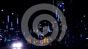 Modern lights of city at night on busy highway. Stock footage. City highway is lit with neon lights and headlights of