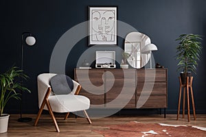 Modern living room interior composition with fluffy armchair, wooden commode, mock up poster frame, vinyl recorder. Copy space.