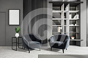 Modern living room interior furnished by two armchair, bookshelf and table. Mock up poster frame on grey wall. Copy space. Home