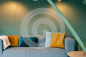 Modern living room sofa and green wall and yellow pillows, scandinavian design