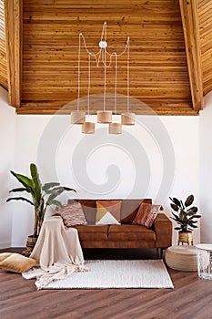 Modern living room with sofa, wooden attic ceiling and big window