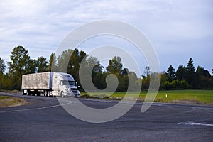 Modern long haul semi truck tarp trailer on straight highway