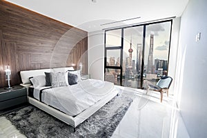 Modern and luxurious hotel bedroom with views of Shanghai Lujiazui Pudong skyline. Condo or 5-star upscale accommodation