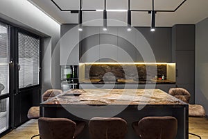 Modern luxury apartment with a free layout in a loft style in gray and dark colors. Stylish kitchen area with an island