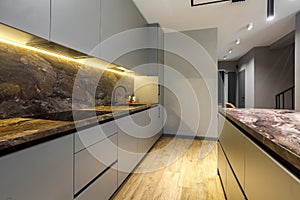 Modern luxury apartment with a free layout in a loft style in gray and dark colors. Stylish kitchen area with an island