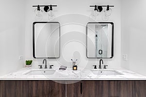 A modern, luxury bathroom with a wood cabinet and marble countertop.