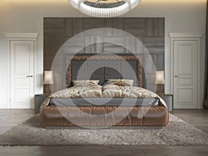 Modern luxury bed in art deco style with quilt and wooden headboard of parquet. Bedroom in brown colors