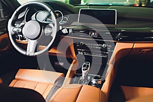 Modern Luxury car inside. Interior of prestige modern car. Comfortable leather brown seats. Orange perforated leather